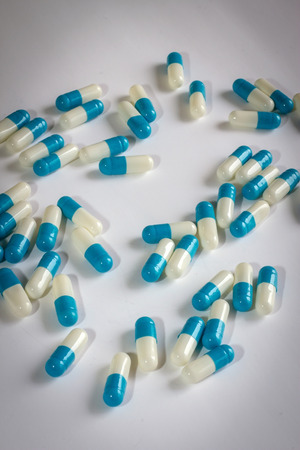 Blue white capsule drug isolated white backgroundの写真素材