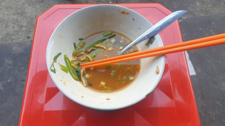 Delicious soup served in a bowl with chopsticks on a striking red tray. A flavorful Asian meal perfect for your culinary projectsの写真素材