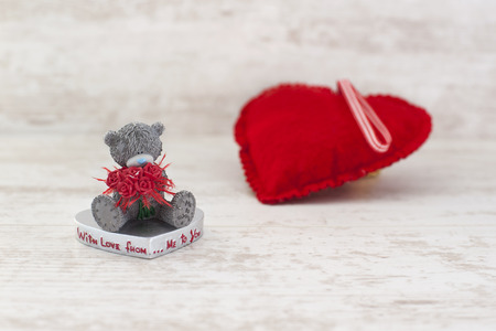 Miniature valentine s day teddy bear and red heart on gray wooden の写真素材