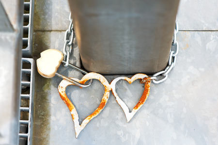 Pair metal love hearts with lock on bridge - wedding tradition. Outdoors closeupの写真素材