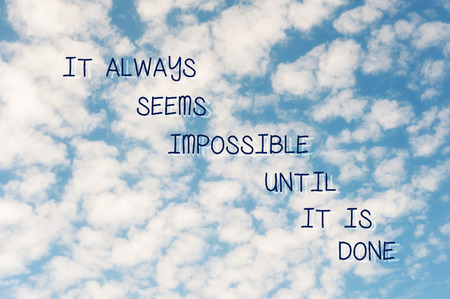 It always seems impossible until it is done. Inspirational motivating quote on soft defocused blue cloudy sky background. Vibrant multicolored outdoors horizontal image. Copy space.の写真素材