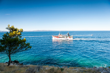 Stunning view of landscape with beautiful Adriatic Sea and quiet majestic bay with floating boat in Dalmatia, Croatia, Europe. Summertime multicolored vibrant outdoors horizontal image with blue sky background.の写真素材