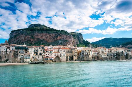 Cefalu, Sicily. Ligurian Sea and cityscape of sunny old medieval sicilian town. Province of Palermo, Italy. Summertime outdoors horizontal image with filter. Panoramic view from seasideの写真素材