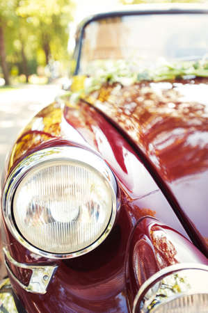 Part of old antique red retro car on ancient castle background. Side view. Colored outdoors horizontal image with filter.の写真素材