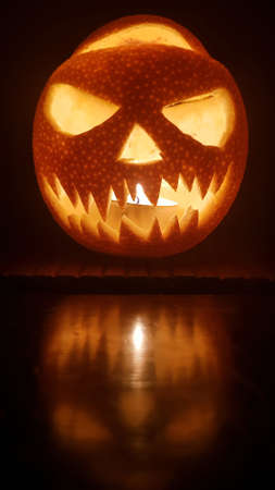 Halloween pumpkin scary smile for party night on dark background. Closeup portrait. Mobile phone vertical image with copy space.の写真素材