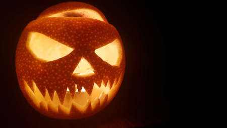 Halloween pumpkin scary smile for party night on dark background. Closeup portrait. Mobile phone horizontal image with copy space.の写真素材