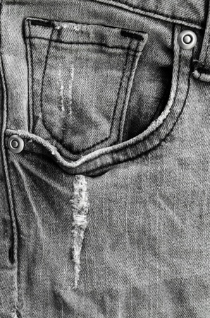 Pockets on the front side of grey jeans with some scratch and buttonsの写真素材