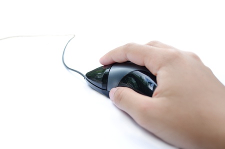 A hand holding a black wired mouseの写真素材
