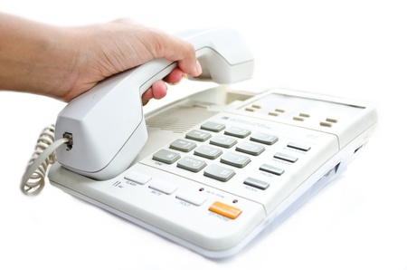 A hand holding a white telephoneの写真素材