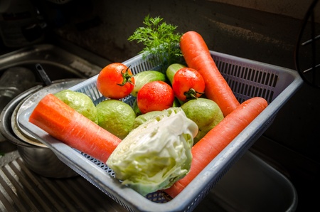 Carrots, tomatoes, cucumbers, cabbage, and guava in a basketの写真素材