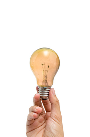 a hand holding a yellow-orange lightbulbの写真素材