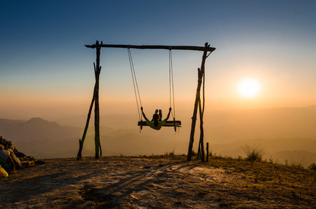 a girl swinging under the sunlightの写真素材