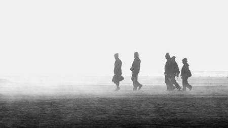 group of five people walking in a land with dustの写真素材