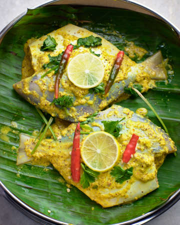 steamed pomfret fish(sea food) with mustard,lemon and chilli,served on banana leafの写真素材