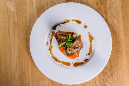 Meat on a white plate on a wooden table closeupの写真素材