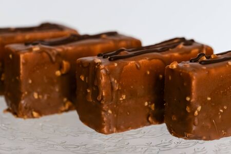 Chocolate ake on a glass stand photographed against a white background closeupの写真素材