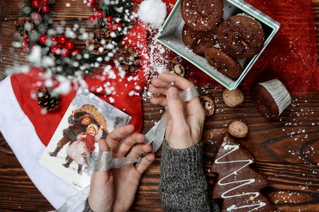 Christmas present. Close-up top view the wooden desk with Christmas decorations laying aroundの写真素材