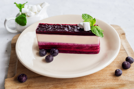 Slice of cheesecake on a white plate closeup shotの写真素材