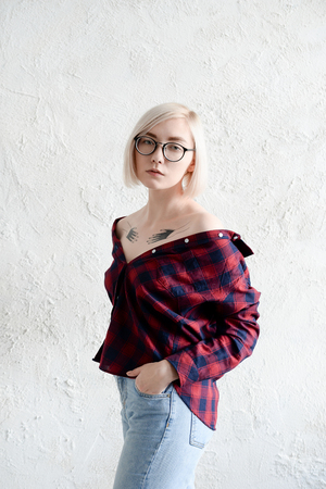 Model blonde with short hair wearing glasses photographed in the studioの写真素材