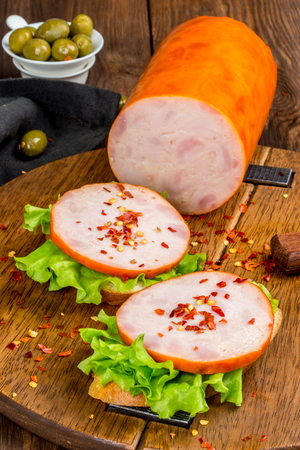 Sausage cut on a wooden board shot close-upの写真素材