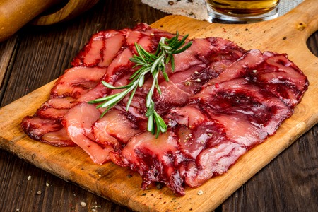 Smoked meat sliced off on a close-up backgroundの写真素材