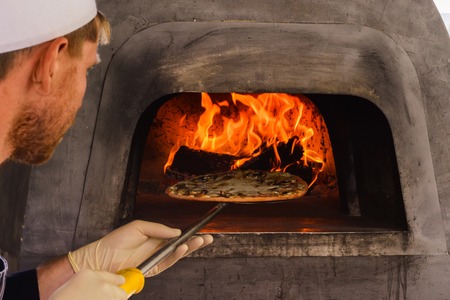 The pizza oven with fire is shot close-up in natural lightの写真素材