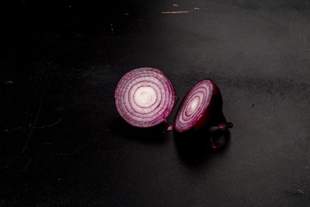 A red onion isolated against a black background. Shot from the sideの写真素材