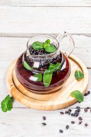 Tea with barberry shot in the decor on a white wooden background. Close-up shotの写真素材