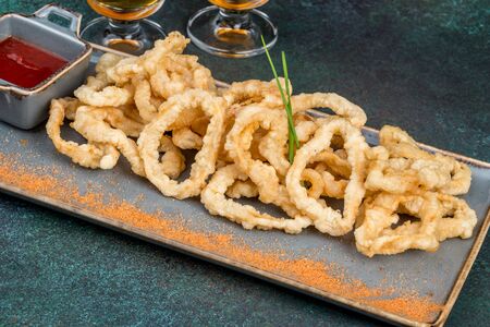 Squid dish in batter with sauce. Close-up shot
