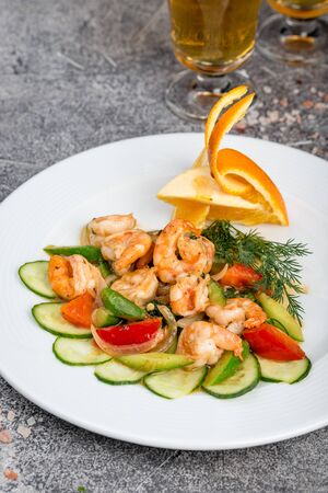 Tiger prawns with vegetables on a white plateの写真素材