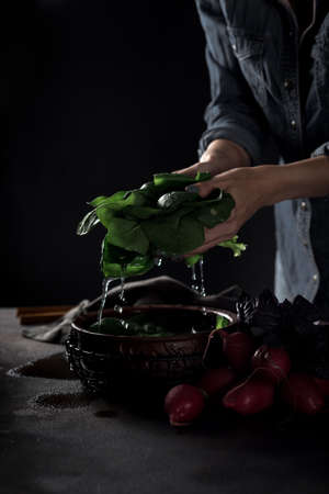 Female hands tossing vegetables in a bowl of water