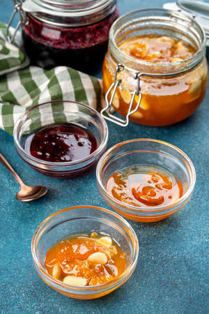 Two types of jam of strawberries and apricots in glass jars