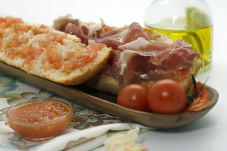 baguette with jamon iberico, tomato on wooden boardの写真素材