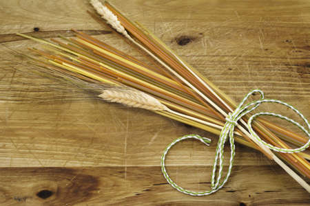 spaguetis vegetables, and bunch of spikes, green bow on rustic woodの写真素材