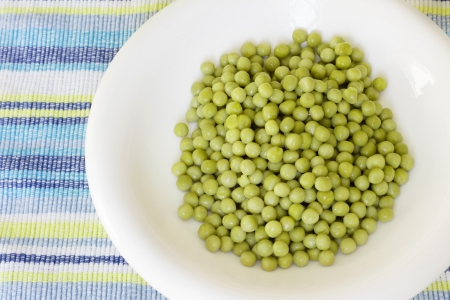 Plate of peas in plate on blue striped backgroundの写真素材