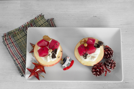 Apples stuffed with cream  Dice fruit, impregnating in you red fruit and chocolate curlsの写真素材