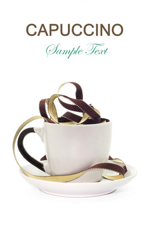 Conceptual series tea and coffees. Cappuccino. Nblanca cup, brown with white polka dots ribbon on isolated background. vertical positionの写真素材
