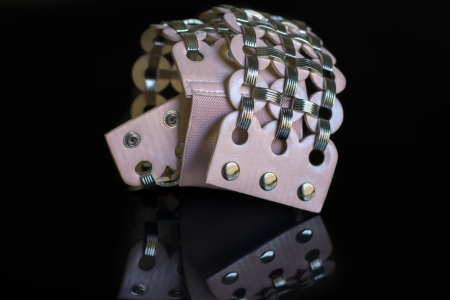 pink leather belt with metal clasps on black backgroundの写真素材
