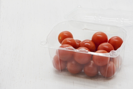 Cherry tomatoes in plastic tray on white backgroundの写真素材