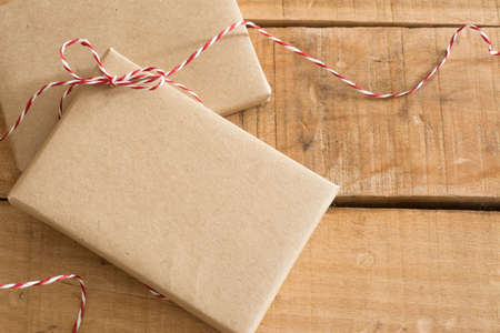 gift box wrapped in recycled paper, with ribbon bow,  with ribbon rustic, red and white の写真素材