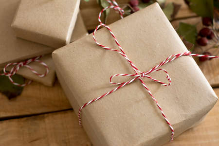 gift box wrapped in recycled paper, with ribbon bow,  with ribbon rustic, red and white の写真素材