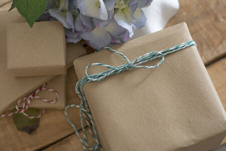gift box wrapped in recycled paper, with ribbon bow,  with ribbon rustic, red and white の写真素材
