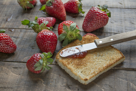 toast, strawberry jam and fresh fruit on dark woodの写真素材