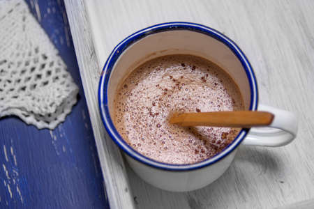 Hot chocolate in white metal cup on rustic background.  intense blue の写真素材
