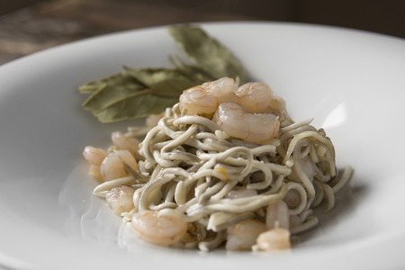 Gulas or surimi, dish prepared with garlic and olive oil, sauteed prawns. Spanish gastronomic delight, dark wood background. Horizontal image.の写真素材