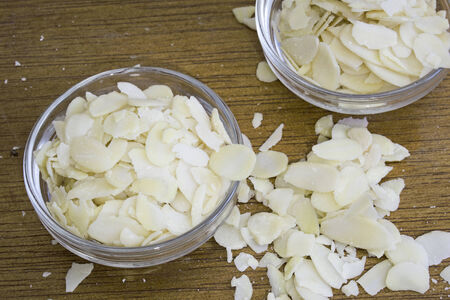blanched almonds flakes, perfect for decorating cakes, on wooden backgroundの写真素材