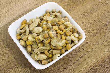 Assorted nuts in square bowl on wooden backgroundの写真素材