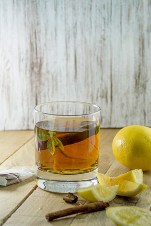 healthy cup of hot tea on wooden background, lemon and cinnamon の写真素材