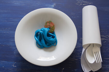 Blue Spaghetti , black place setting, pasta dyed with food coloring on rustic wooden table black