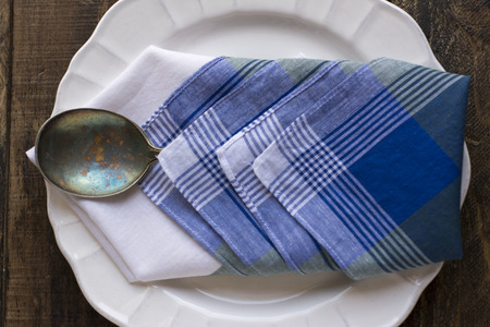 White plate, antique spoon on blue napkin. wooden backgroundの写真素材
